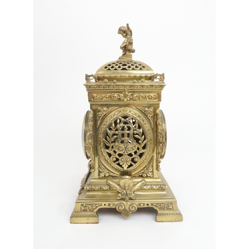 398 - A FRENCH BRASS MANTLE CLOCKwith cherub finial and central mask above the dial, the dial with arabic ... 