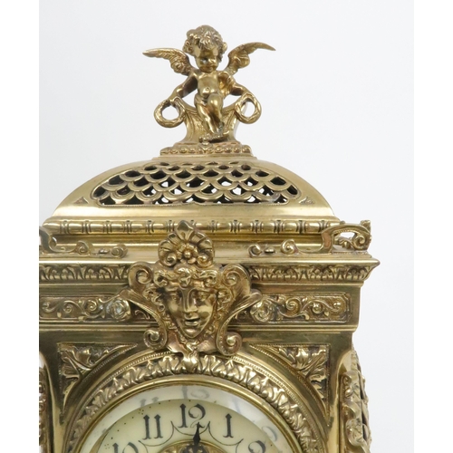 398 - A FRENCH BRASS MANTLE CLOCKwith cherub finial and central mask above the dial, the dial with arabic ... 