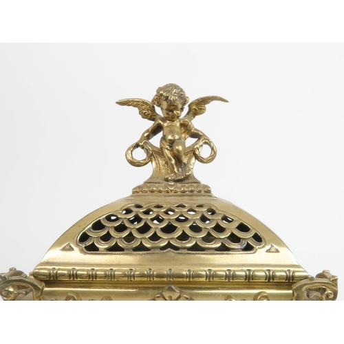 398 - A FRENCH BRASS MANTLE CLOCKwith cherub finial and central mask above the dial, the dial with arabic ... 