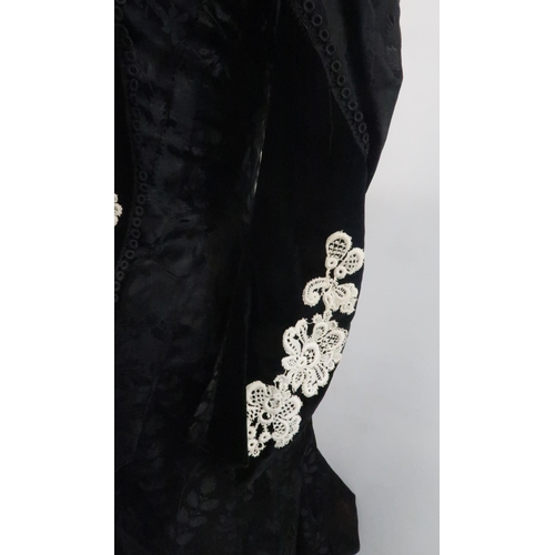 571 - A VICTORIAN MOURNING DRESS IN BLACK FLORALpatterned crepe with applied white lace to black velvet co... 