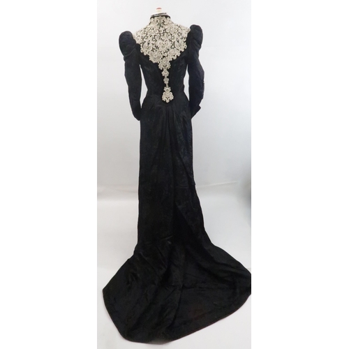 571 - A VICTORIAN MOURNING DRESS IN BLACK FLORALpatterned crepe with applied white lace to black velvet co... 