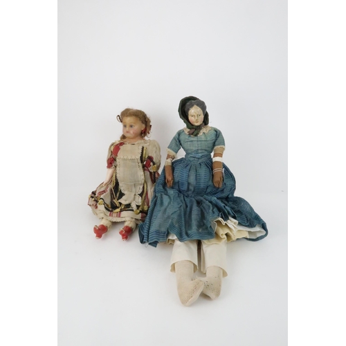 574 - AN EARLY PAPIER MACHE SHOULDER HEAD DOLLwith painted features, with dress and bonnet, 69cm long and ... 