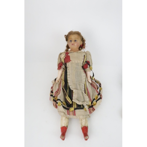 574 - AN EARLY PAPIER MACHE SHOULDER HEAD DOLLwith painted features, with dress and bonnet, 69cm long and ... 