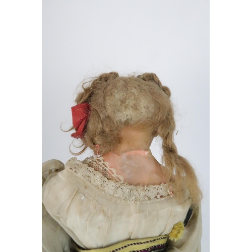 574 - AN EARLY PAPIER MACHE SHOULDER HEAD DOLLwith painted features, with dress and bonnet, 69cm long and ... 