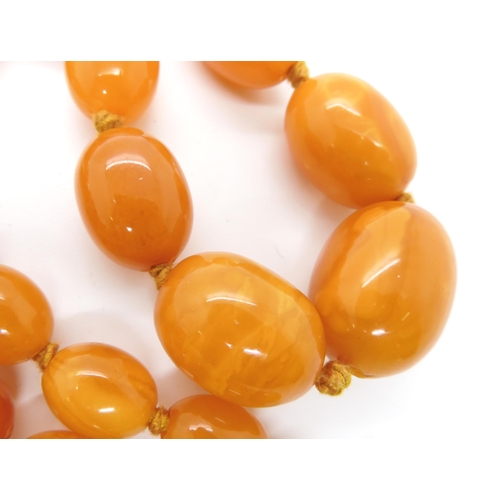 707 - A STRING OF BUTTERSCOTCH COLOUR AMBER BEADS strung length 97cm, weight 74.6gms (with one spare loose... 