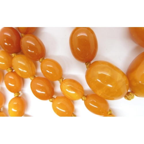 707 - A STRING OF BUTTERSCOTCH COLOUR AMBER BEADS strung length 97cm, weight 74.6gms (with one spare loose... 