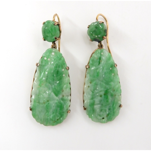 713 - A PAIR OF CHINESE GREEN HARDSTONE EARRINGS mounted in yellow metal with the hardstones, pierced and ... 