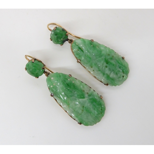 713 - A PAIR OF CHINESE GREEN HARDSTONE EARRINGS mounted in yellow metal with the hardstones, pierced and ... 