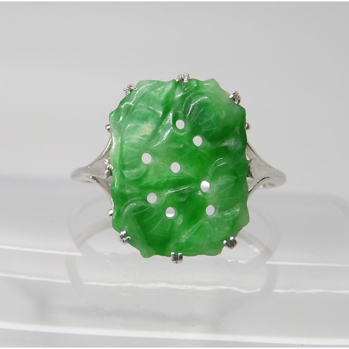 725 - AN 18CT WHITE GOLD CHINESE GREEN HARDSTONE RING the hardstone is pierced carved with fruit, measurin... 