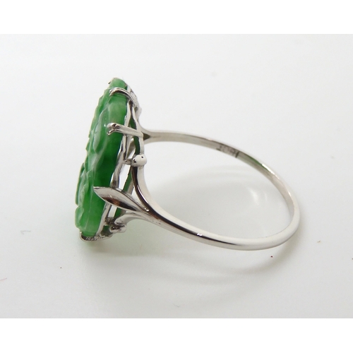 725 - AN 18CT WHITE GOLD CHINESE GREEN HARDSTONE RING the hardstone is pierced carved with fruit, measurin... 