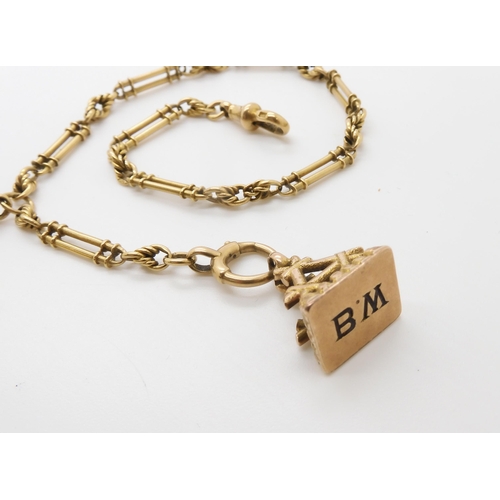 785 - AN 18CT GOLD FANCY FOB CHAIN together with a bright yellow metal fancy fob seal engraved with monogr... 