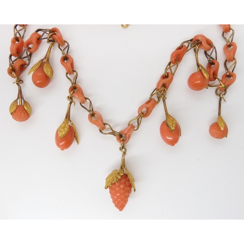 824 - A CARVED CORAL FRUIT NECKLACEthe fruit mounted with engraved and chased yellow metal leaves, with co... 