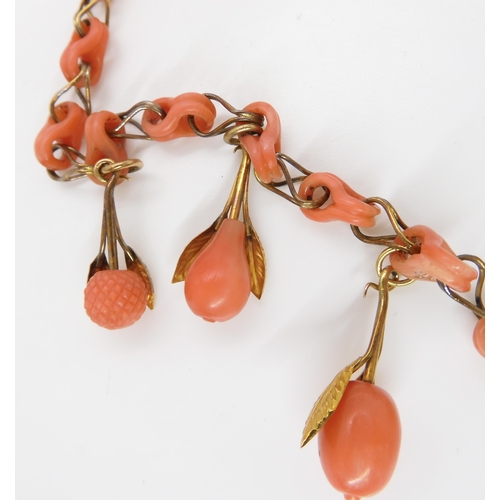 824 - A CARVED CORAL FRUIT NECKLACEthe fruit mounted with engraved and chased yellow metal leaves, with co... 