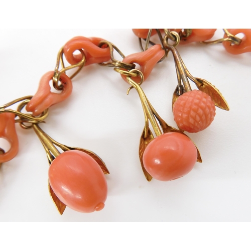 824 - A CARVED CORAL FRUIT NECKLACEthe fruit mounted with engraved and chased yellow metal leaves, with co... 