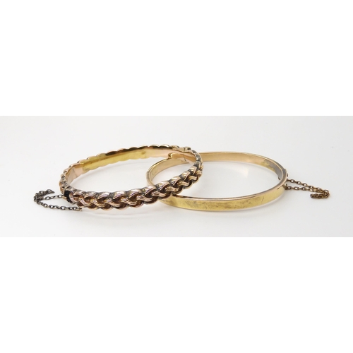 834 - TWO BRIGHT YELLOW METAL VINTAGE BANGLESa knot pattern bangle, with all over pattern and box clasp. I... 