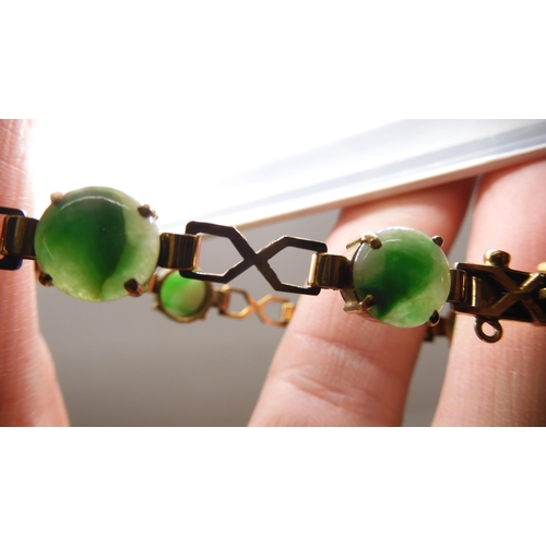 835 - A 9CT GOLD CHINESE GREEN HARDSTONE BRACELETthe hardstones measure 8.3mm approx each with decorative ... 