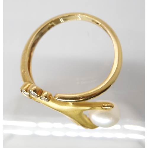 847 - A CONTINENTAL DIAMOND AND PEARL HAND RINGmade in bright yellow metal the elegant hand holds a pearl,... 