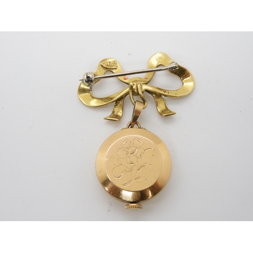 878 - A LADIES 18K GOLD LIDHER FOB WATCH with 18k gold bow brooch attached. The white dial with copper col... 