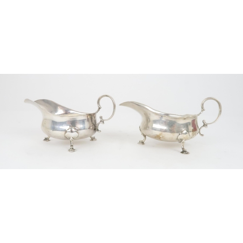 905 - A CASED PAIR OF SILVER SAUCEBOATS by Martin Hall & Co. Sheffield 1919, of classic form with scro... 