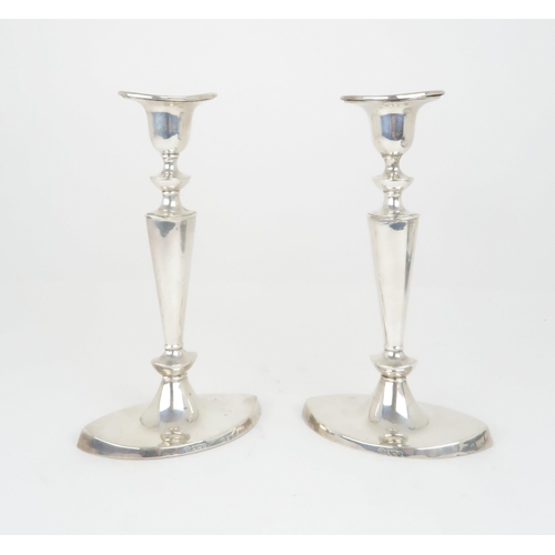 908 - A PAIR OF SILVER CANDLESTICKS by William Hutton & Sons Ltd the removable drip pans on oval taper... 