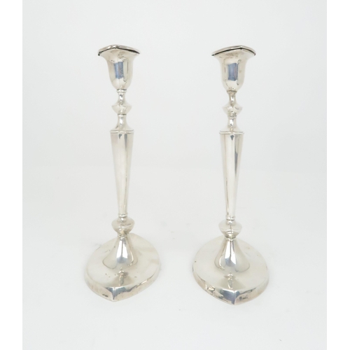 908 - A PAIR OF SILVER CANDLESTICKS by William Hutton & Sons Ltd the removable drip pans on oval taper... 