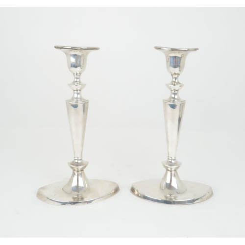 908 - A PAIR OF SILVER CANDLESTICKS by William Hutton & Sons Ltd the removable drip pans on oval taper... 