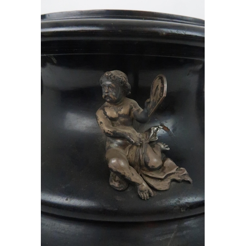 933 - AN EBONISED WOODEN STANDof circular form the concave side applied with seven silver cherubs by Thoma... 