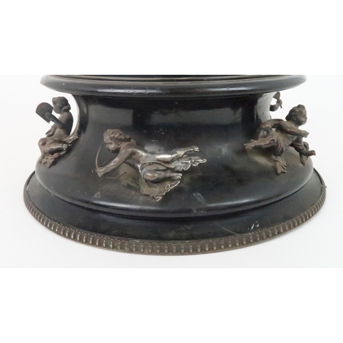 933 - AN EBONISED WOODEN STANDof circular form the concave side applied with seven silver cherubs by Thoma... 