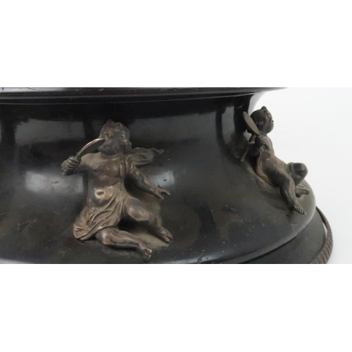 933 - AN EBONISED WOODEN STANDof circular form the concave side applied with seven silver cherubs by Thoma... 