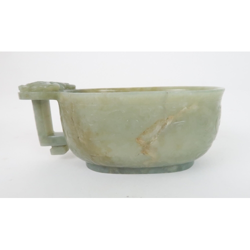 201 - A CHINESE JADE ARCHAIC STYLE VESSEL carved with dragons amongst cloud scrolls, the protruding handle... 