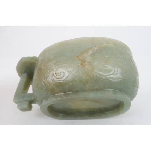 201 - A CHINESE JADE ARCHAIC STYLE VESSEL carved with dragons amongst cloud scrolls, the protruding handle... 