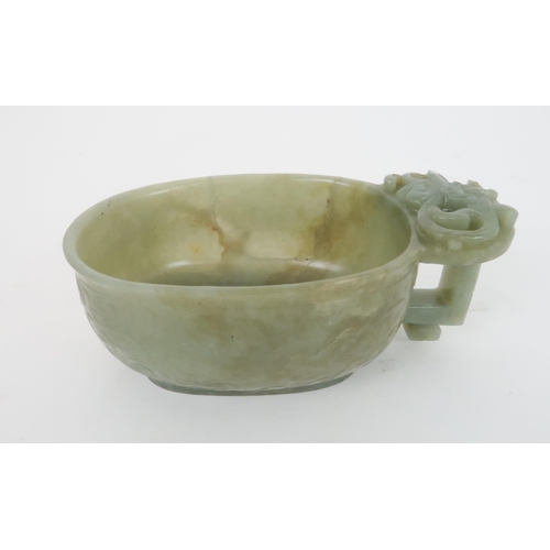 201 - A CHINESE JADE ARCHAIC STYLE VESSEL carved with dragons amongst cloud scrolls, the protruding handle... 