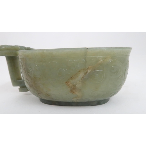 201 - A CHINESE JADE ARCHAIC STYLE VESSEL carved with dragons amongst cloud scrolls, the protruding handle... 