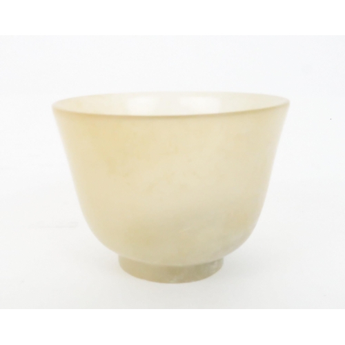 202 - A CHINESE HARDSTONE TWO HANDLED CUP the handles carved with pierced lotus, 4.5cm high and 9.5cm wide... 