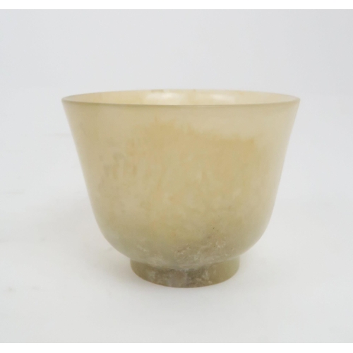 202 - A CHINESE HARDSTONE TWO HANDLED CUP the handles carved with pierced lotus, 4.5cm high and 9.5cm wide... 