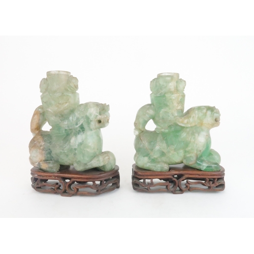 216 - A PAIR OF CHINESE FLUORITE CARVED SHISHIeach seated and resting on a ball, with foliate carved vases... 