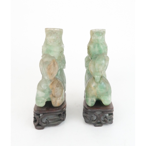 216 - A PAIR OF CHINESE FLUORITE CARVED SHISHIeach seated and resting on a ball, with foliate carved vases... 