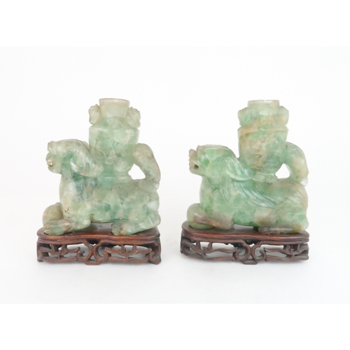 216 - A PAIR OF CHINESE FLUORITE CARVED SHISHIeach seated and resting on a ball, with foliate carved vases... 