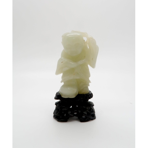 235 - A CHINESE JADE CARVING OF A FIGURE standing on the three legged toad and holding a pomegranate branc... 