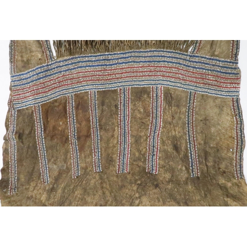 258 - AN AMERICAN PLAINS INDIAN APRONThe animal skin woven with rows of beadwork in red, white and blue, 8... 