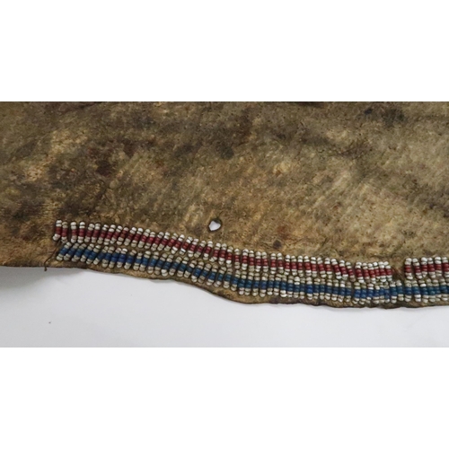 258 - AN AMERICAN PLAINS INDIAN APRONThe animal skin woven with rows of beadwork in red, white and blue, 8... 