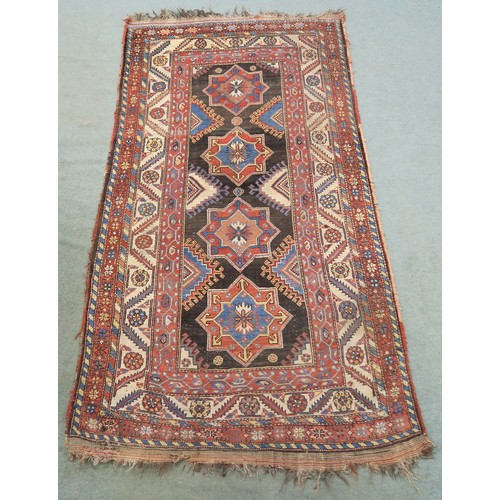 120A - A BLACK GROUND CAUCASIAN RUG, with four medallions and multicoloured borders, 246cm long x 137cm wid... 