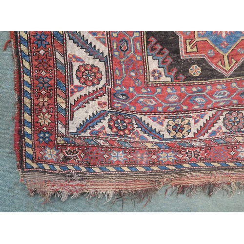 120A - A BLACK GROUND CAUCASIAN RUG, with four medallions and multicoloured borders, 246cm long x 137cm wid... 