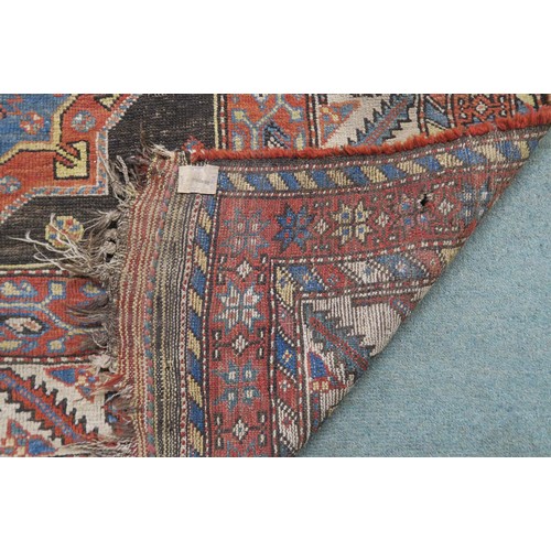 120A - A BLACK GROUND CAUCASIAN RUG, with four medallions and multicoloured borders, 246cm long x 137cm wid... 