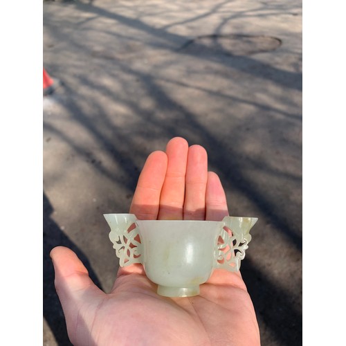 202 - A CHINESE HARDSTONE TWO HANDLED CUP the handles carved with pierced lotus, 4.5cm high and 9.5cm wide... 