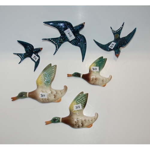 318 - A set of three Beswick flying swallow wall plaques, together with a continental group of flying duck...