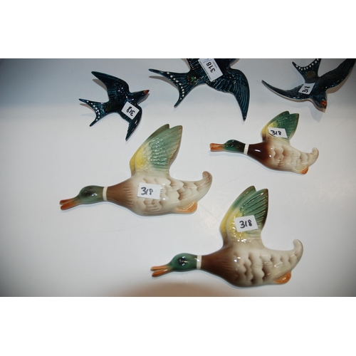 318 - A set of three Beswick flying swallow wall plaques, together with a continental group of flying duck...