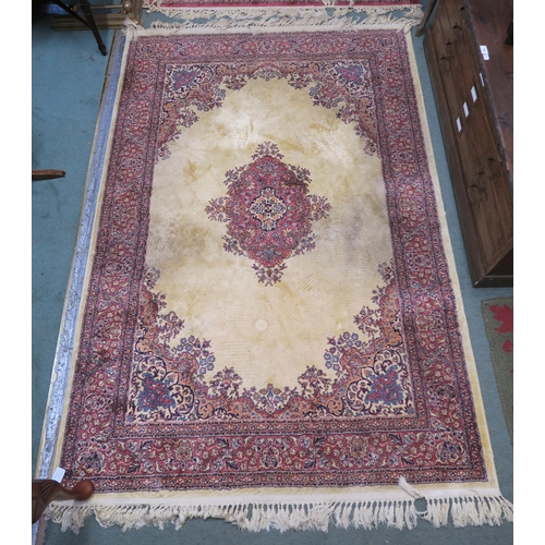 92 - A beige ground kashan rug with pink central medallion and matching borders, 204cm long x 128cm wide