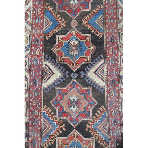 131 - A BLACK GROUND CAUCASIAN RUGwith four medallions and multicoloured borders, 246cm long x 137cm wide... 