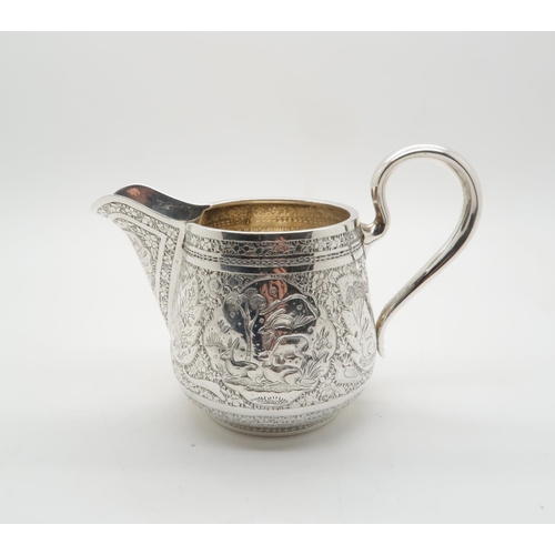 352 - A Russian silver cream jug, with chased decoration of riders and animals within cartouches, surround... 